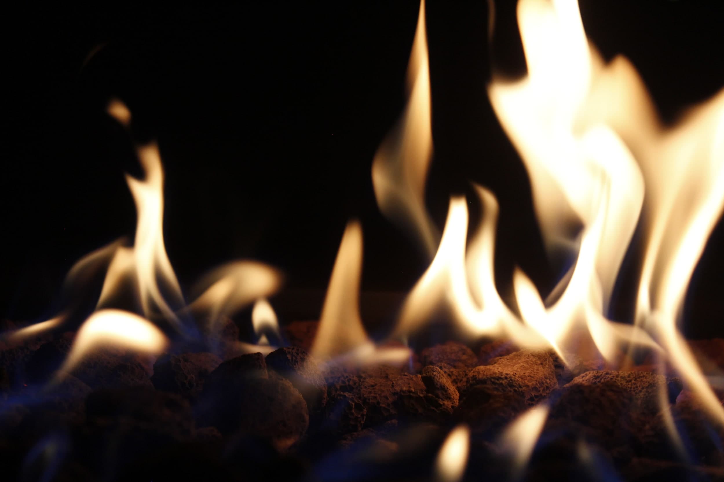 Close-up of flames over glowing lava rocks